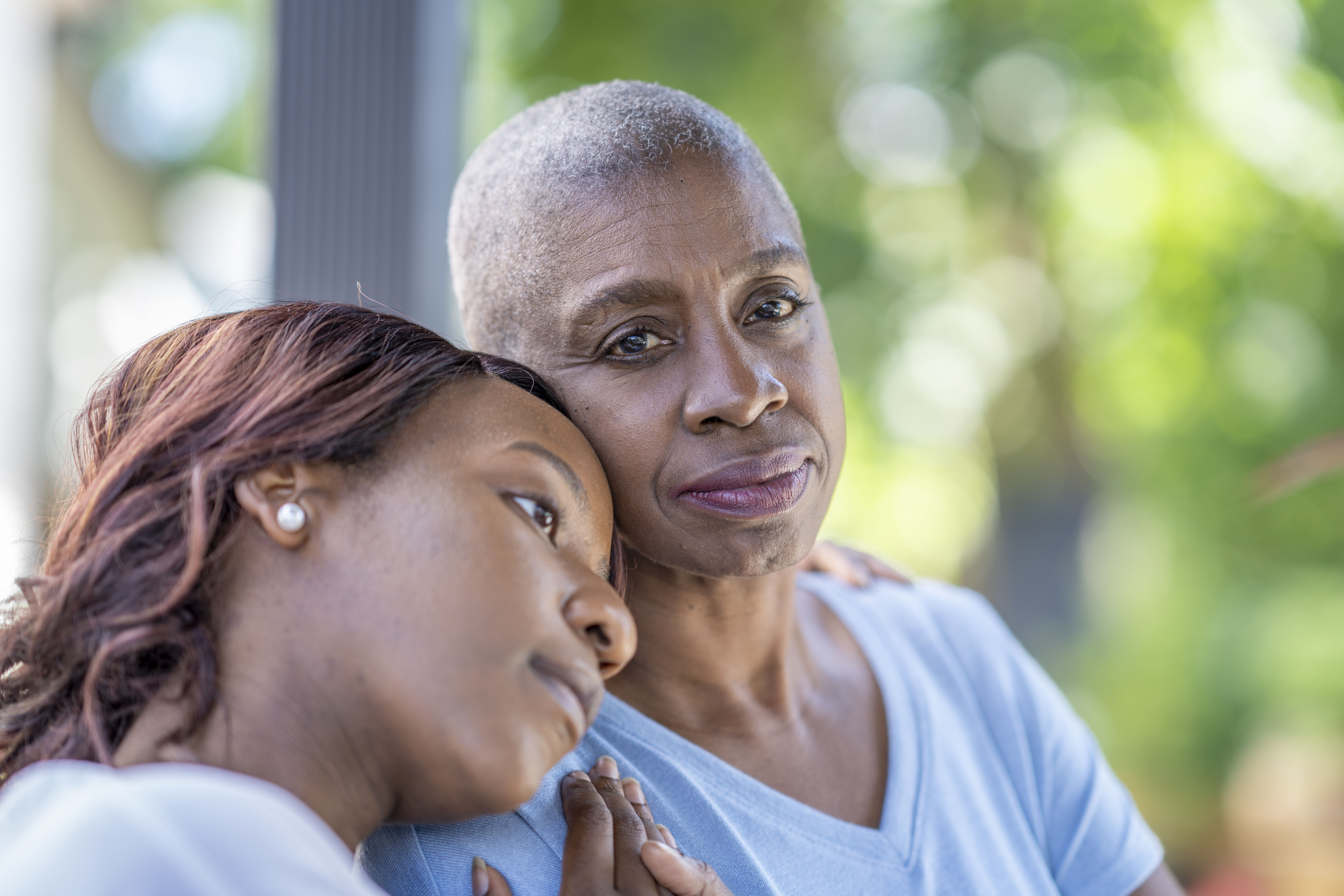 Daughter resting her head on her grieving mother
