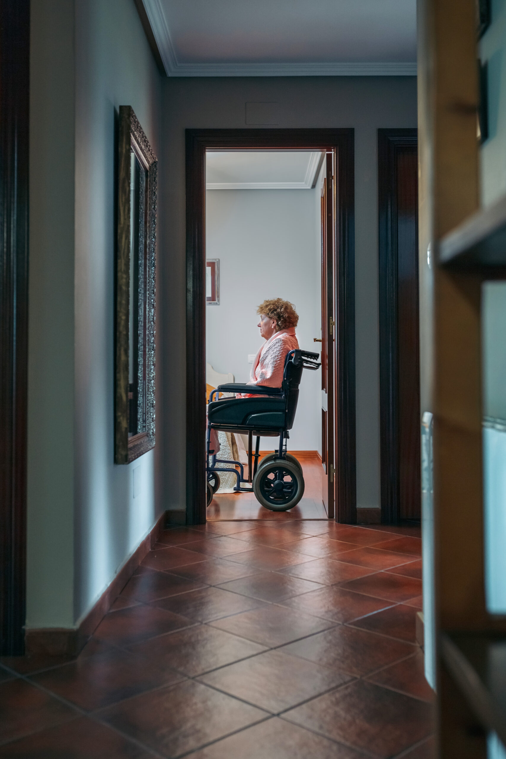 Elderly woman in a wheelchair in her nursing home room